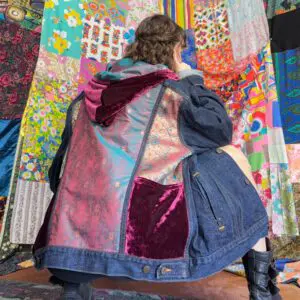 Crouching person wearing patchwork denim jacket