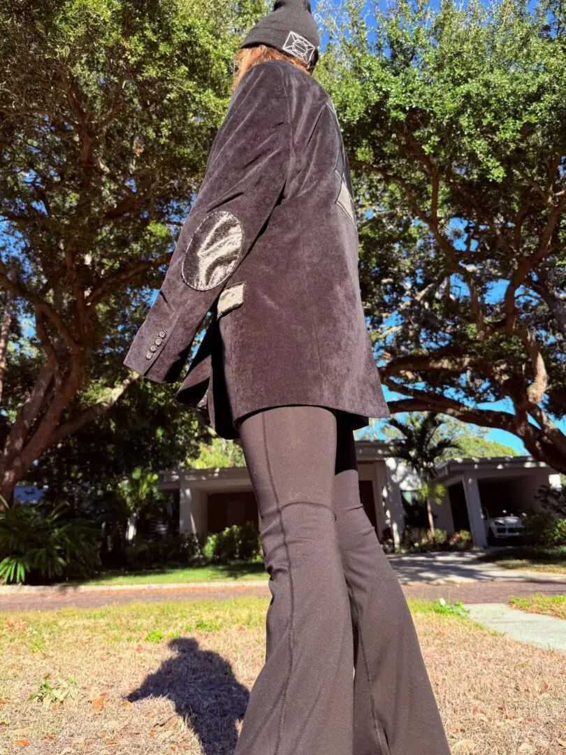 Person in black jacket, beanie, flared pants