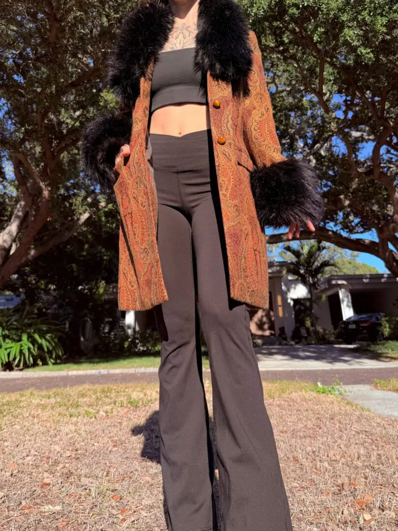 Person wearing paisley coat with black flared pants