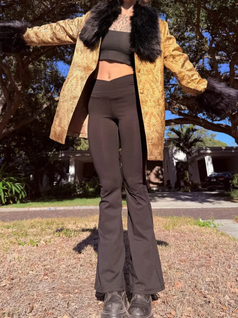 Person in gold fur-trim coat and black outfit
