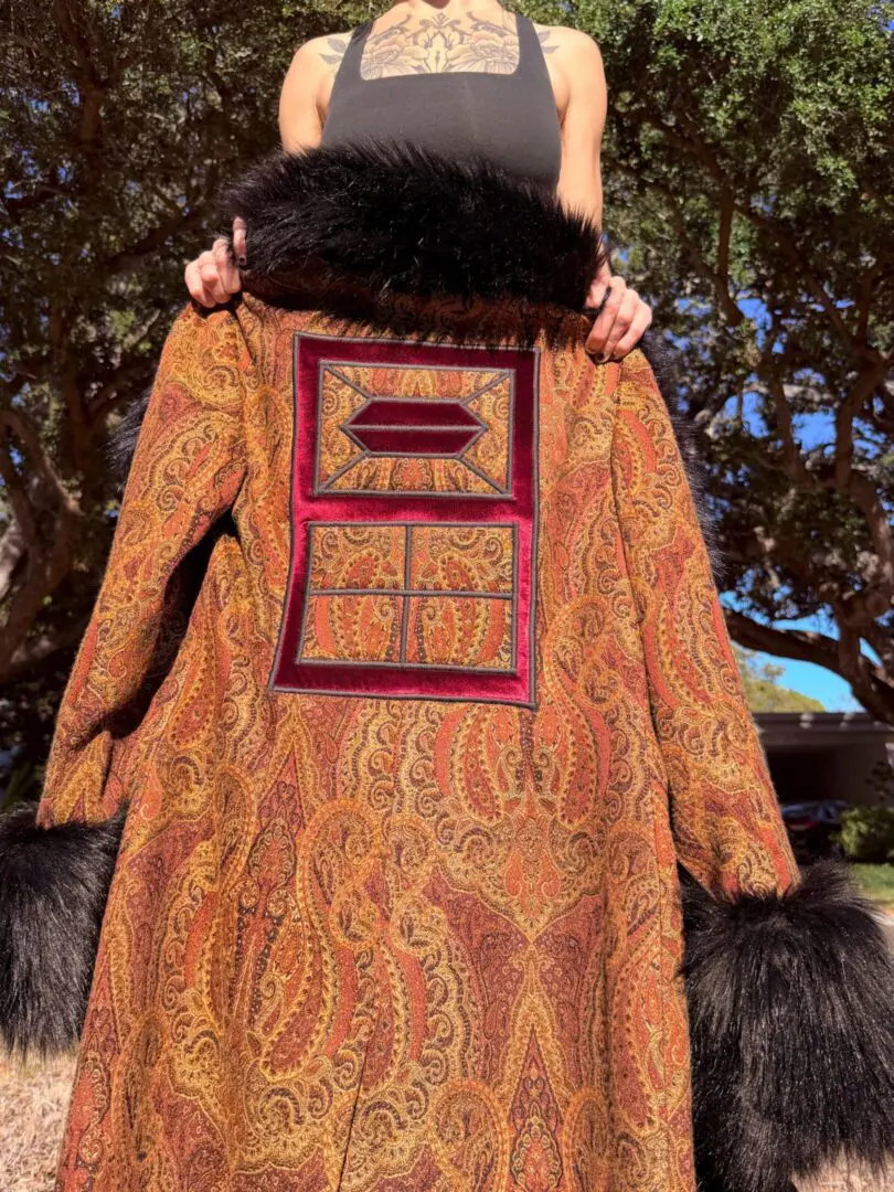Ornate paisley coat with black fur trim