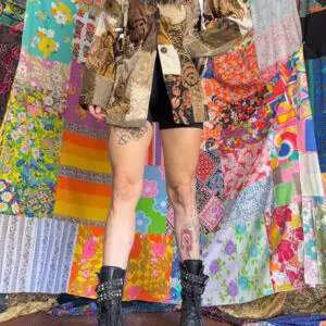 Person in fur-collared patchwork coat and boots