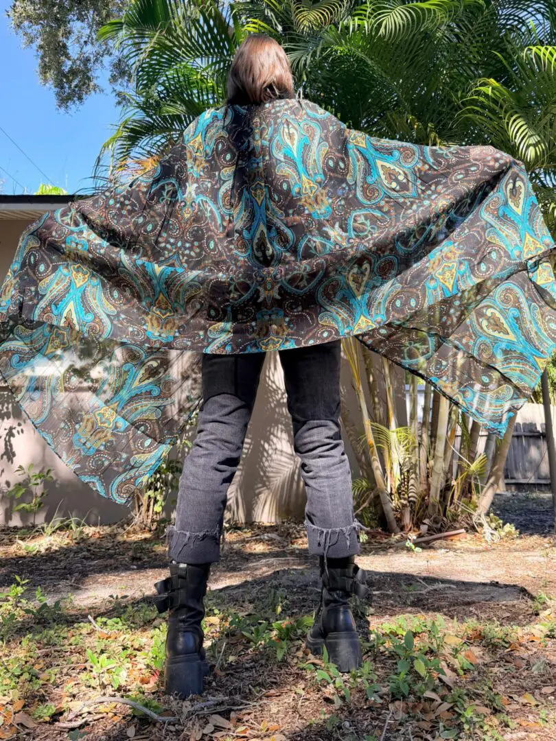 Person wearing flowing paisley shawl outdoors