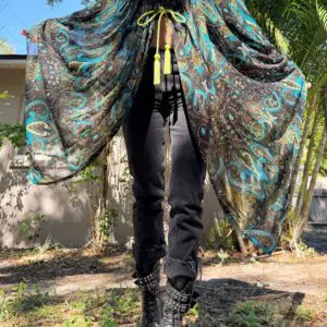 Person wearing paisley cape and combat boots