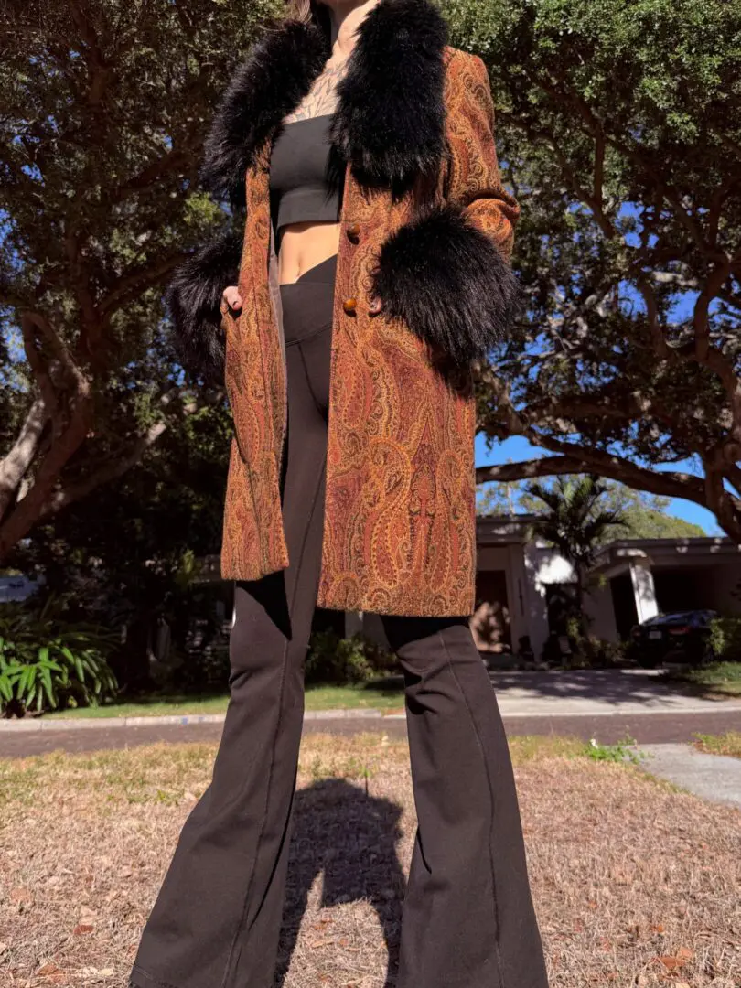 Person wearing paisley coat and flared pants