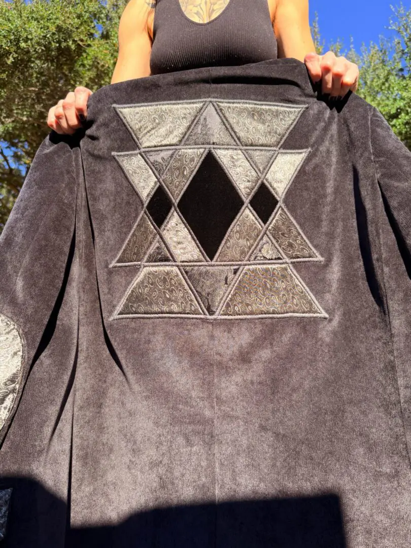 Dark jacket with embroidered interlocking triangle design