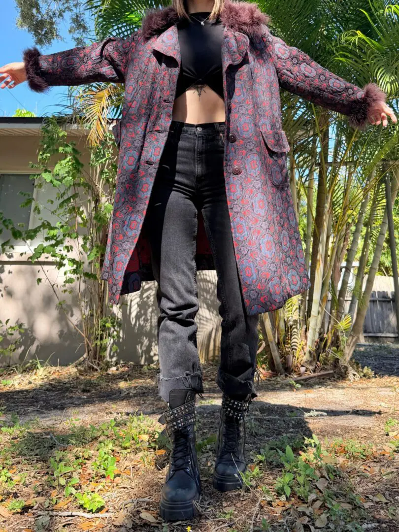 Person wearing patterned coat and studded boots