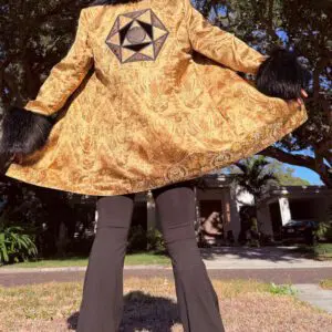 Person in gold coat with geometric star