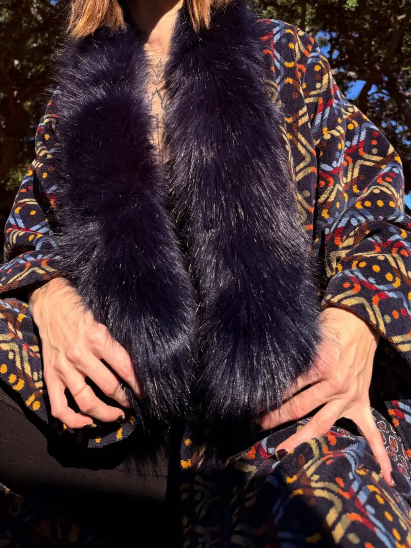 Person wearing patterned coat with dark fur collar