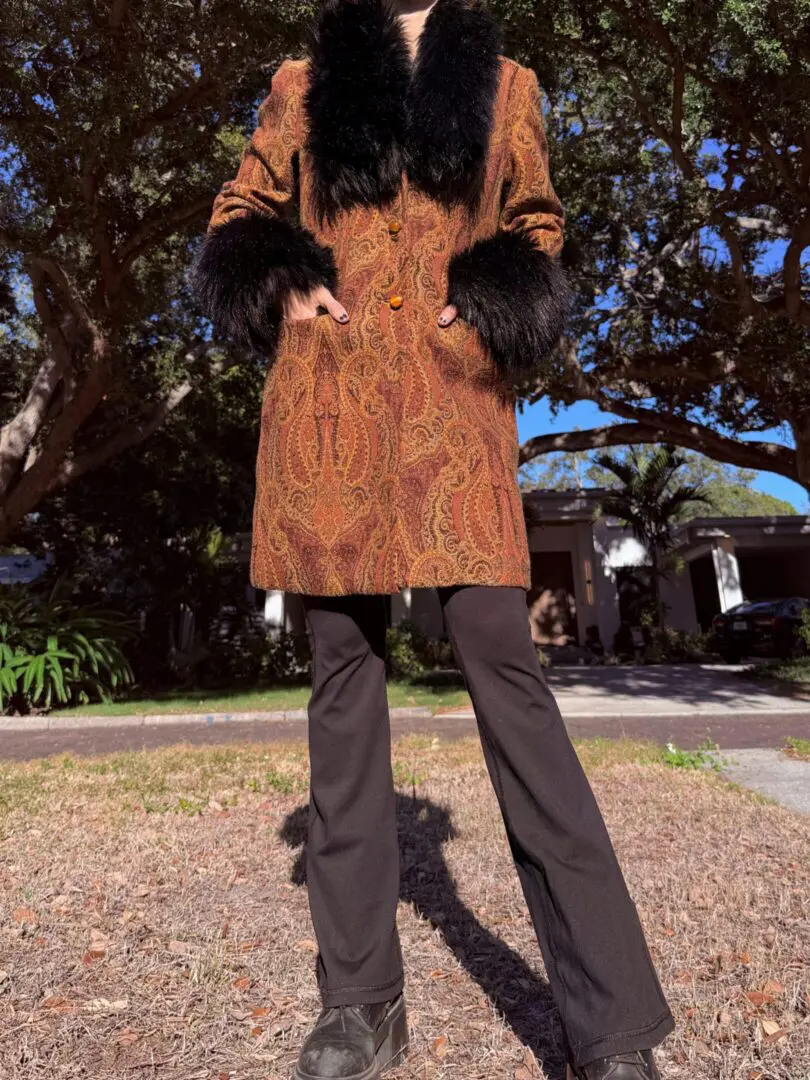 Person wearing paisley coat with black fur trim
