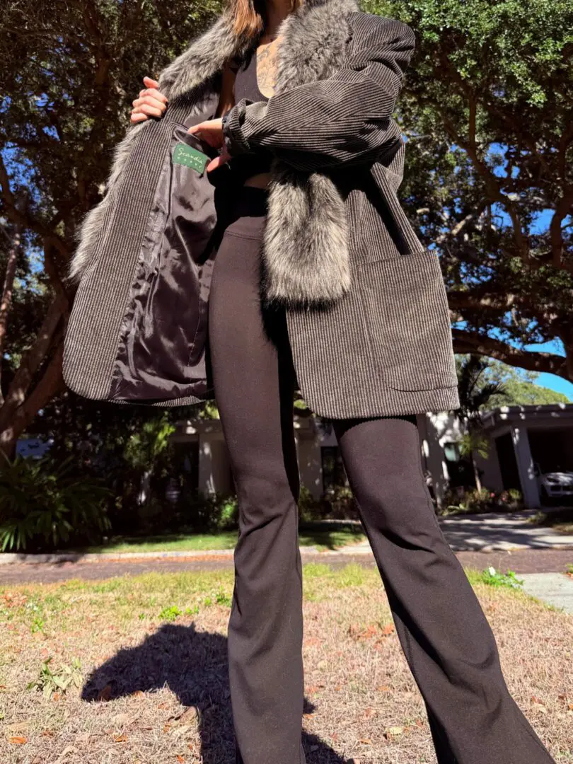 Person wearing fur-trimmed coat and black pants