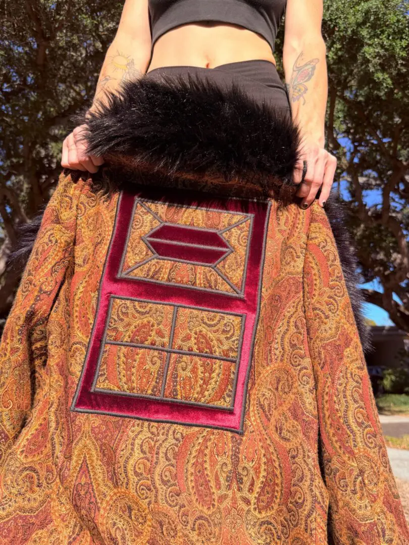 Ornate paisley coat with black fur collar