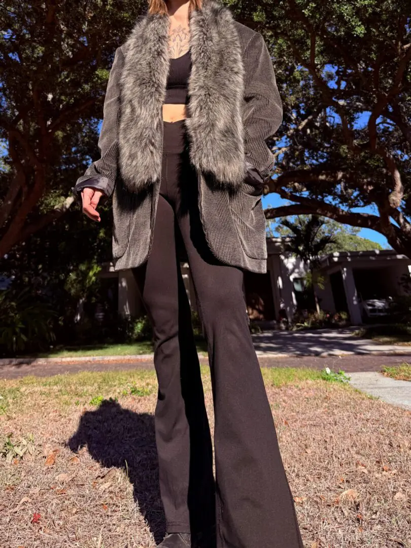 Person wearing fur-collar coat and flared pants