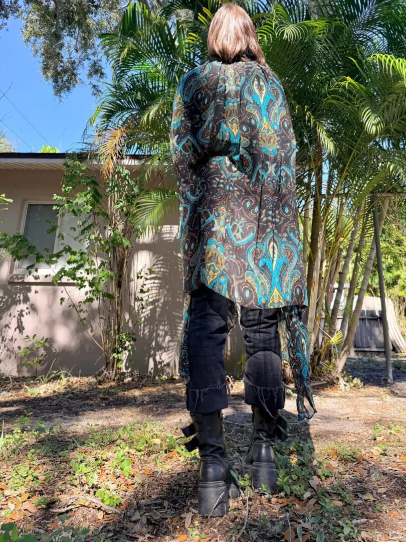 Person in teal paisley coat, black platform boots
