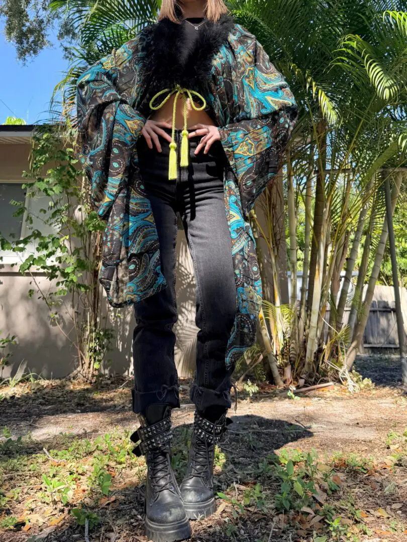 Person in paisley kimono, black jeans, boots