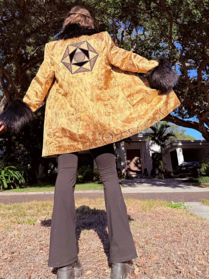 Person in gold brocade coat with geometric patch