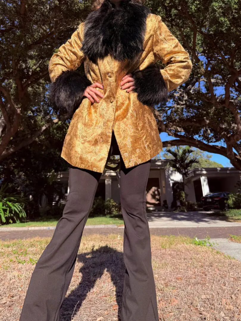 Person in gold brocade coat with fur trim
