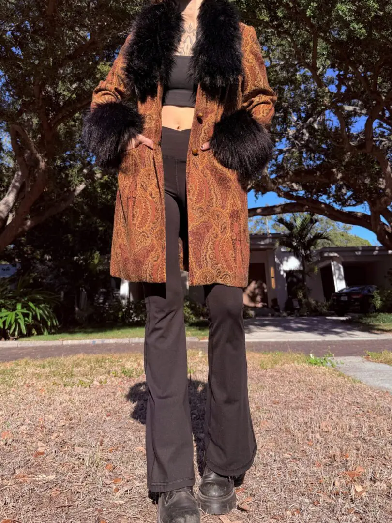 Person wearing paisley coat with black fur