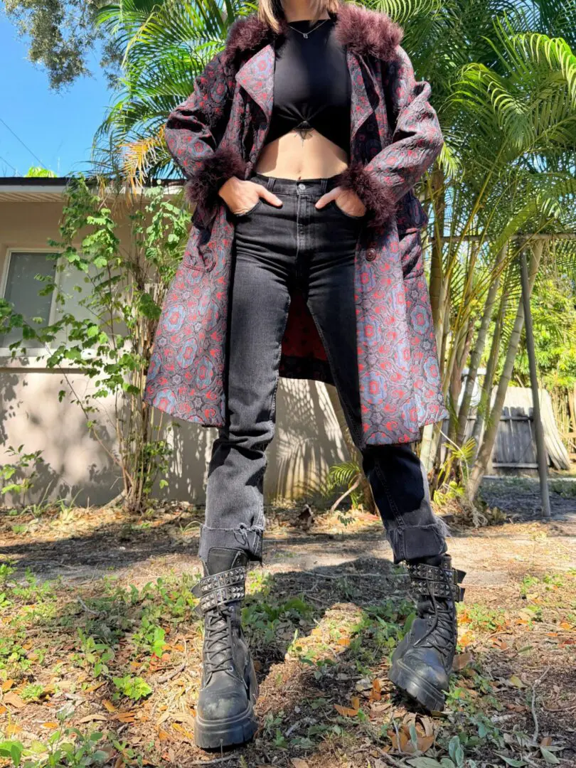 Person wearing patterned coat, crop top, combat boots